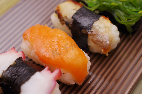 竹盘子摄影照片_寿司握寿司在盘子里用竹棍