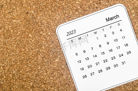 2023 年 3 月木制背景的月历。