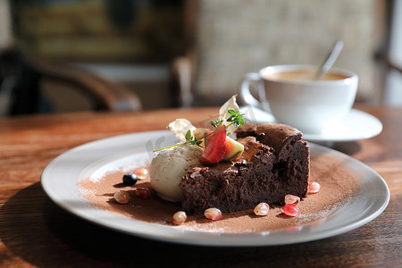 巧克力蛋糕摄影照片_木桌上的巧克力蛋糕、冰淇淋和咖啡甜点