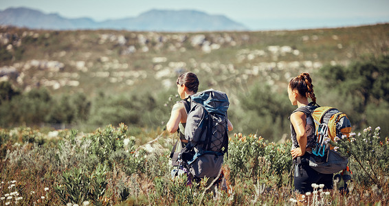 锻炼朋友或女性徒步旅行、健身或锻炼，在山间尘土小路上行走在大自然中。