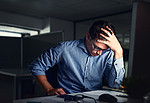 压力大、疲惫的商人患有头痛，在办公室工作到深夜。