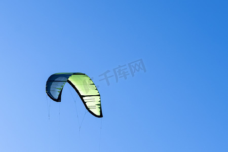 风筝冲浪的翅膀映衬在蓝天上。