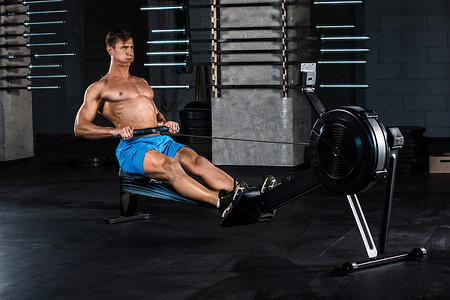 肌肉男摄影照片_肌肉男在健身房锻炼腿部