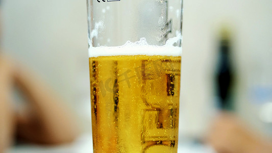 特写镜头，一品脱玻璃杯，里面有冷淡的啤酒。