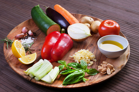 胡萝卜汁摄影照片_汤的配料蔬菜，配香蒜酱和罗勒，放在木盘上。