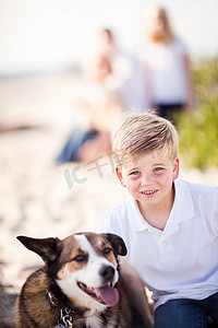 英俊的小男孩和他的狗玩耍
