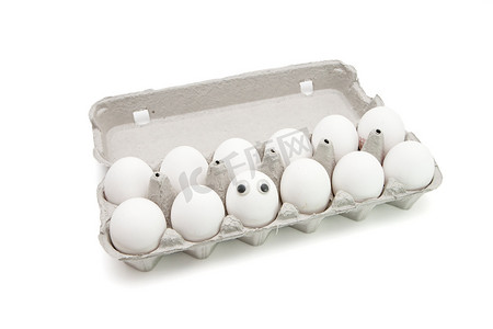 有趣纸盒摄影照片_白色背景的纸盒里有十几只眼睛的滑稽鸡蛋