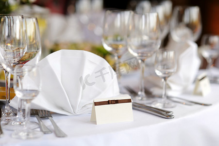 婚姻邀请函摄影照片_将卡片放在白色的节日餐桌上