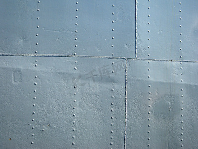 嵌缝摄影照片_带接缝和铆钉的详细灰色金属历史船墙