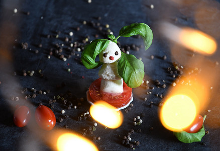 创意宝宝辅食摄影照片_一品红背景下的马苏里拉奶酪、西红柿创意雪人小食