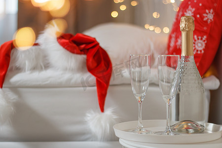 香槟图案摄影照片_圣诞装饰的酒店房间里有两杯和一瓶香槟。
