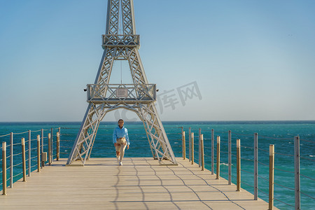 埃菲尔铁塔装饰摄影照片_海滩上的埃菲尔铁塔大型模型。
