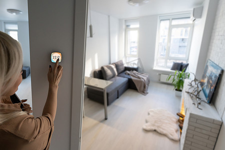 智能家居摄影照片_用智能家居控制家庭供暖温度，特写电话。