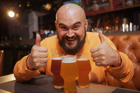 留胡子的男人在酒吧享受喝啤酒