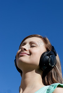 高端大气黑金海报摄影照片_美丽的女人在户外听音乐