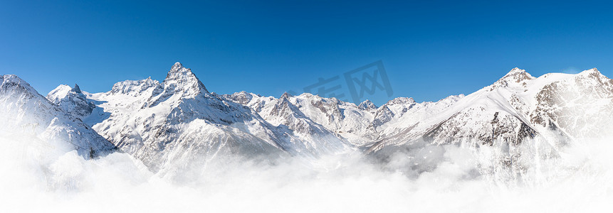 山地助力车摄影照片_俄罗斯高加索地区冬季雪山全景，蓝天