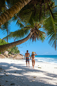 格拉迪斯摄影照片_塞舌尔拉迪格岛安斯帕塔茨，一对年轻夫妇在塞舌尔的热带海滩上享受豪华假期。