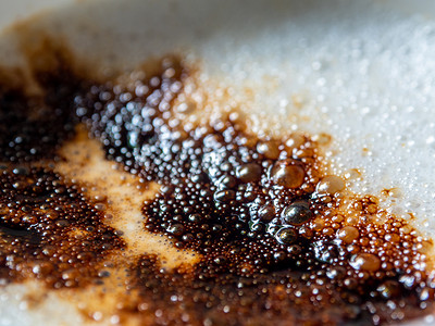 咖啡杯中柔软的白色牛奶泡沫和撒在上面的深棕色咖啡粉