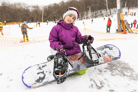 小可爱的女孩学习骑儿童滑雪板，孩子的冬季运动，积极运动的安全。