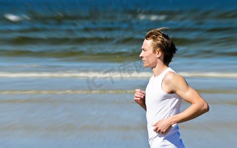 运动模糊：运动的年轻男性在海滩上跑步