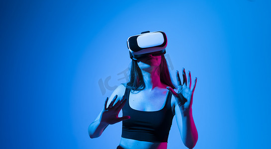 戴着 VR 耳机的黑发女人触摸她在虚拟世界中看到的东西。