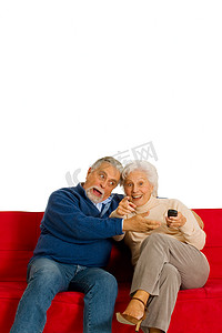 老夫妇在沙发上用电视遥控器