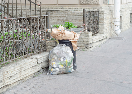 街上满溢的垃圾箱和装满垃圾的塑料包装。