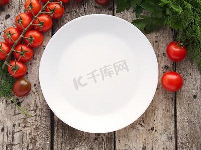干净的空白盘和蔬菜、番茄、欧芹，旧质朴的木质灰色背景，顶视图