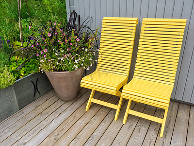 黄色椅子摄影照片_黄色椅子和鲜花装饰房屋外部