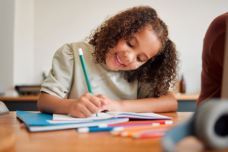 学习、微笑和富有创意的年轻女孩用彩色铅笔画画，感到快乐和满足。