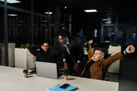 临夏民族大剧院摄影照片_非洲黑人和亚洲员工的多民族团队合作，一起在笔记本电脑上工作。