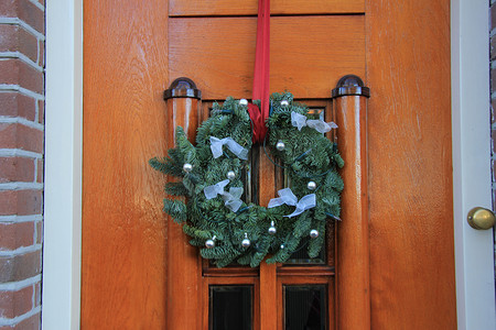 圣诞花环摄影照片_门上有装饰的经典圣诞花环
