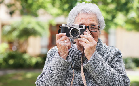 退休、放松和有摄影师爱好的老年妇女在花园里享受养老休闲。