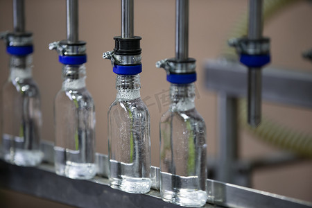 传送带上的一排玻璃瓶用于生产酒精饮料。