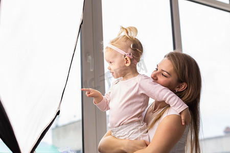 学手语摄影照片_植入人工耳蜗的小女孩和她的母亲在家。