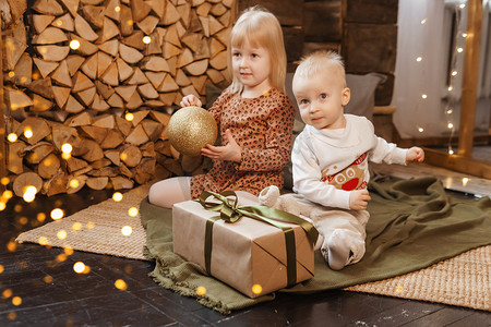 圣诞节前夕，弟弟和妹妹在一栋为新年假期装饰的漂亮房子里玩耍。