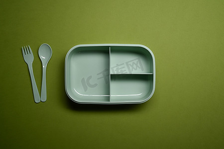 以上视图午餐盒，绿色背景上有勺子和叉子。