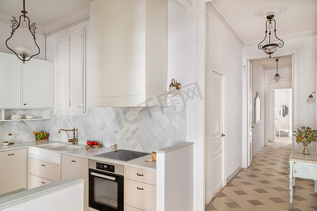 走廊和厨房配有白色家具和瓷砖在明亮的小屋里。