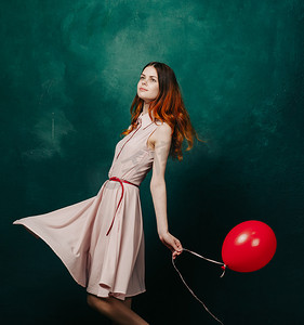 英文版生日快乐摄影照片_穿着红色气球生日绿色背景的漂亮女人