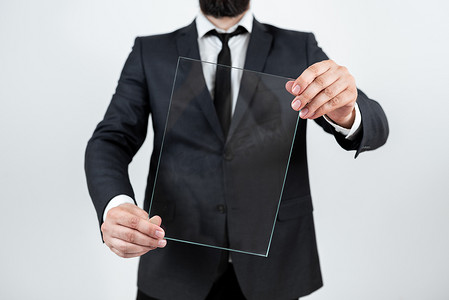 男性企业持有透明玻璃并显示重要公告。