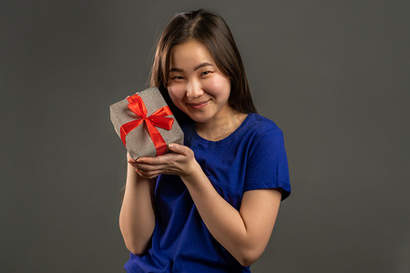 兴奋的亚洲女孩收到了带蝴蝶结的礼品盒。