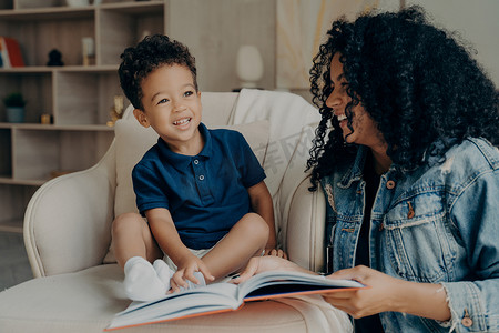 可爱的非洲裔美国母亲给她的小儿子读书，笑着