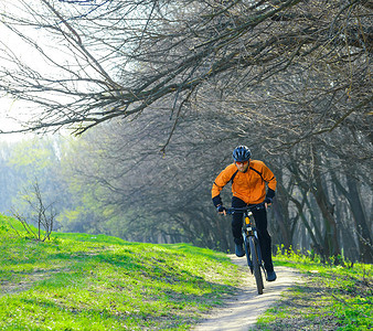 骑男孩摄影照片_骑自行车的人在森林小路上骑自行车