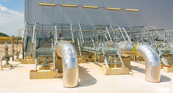 石油化工摄影照片_一排用起重机和其他设备输送天然气的管道