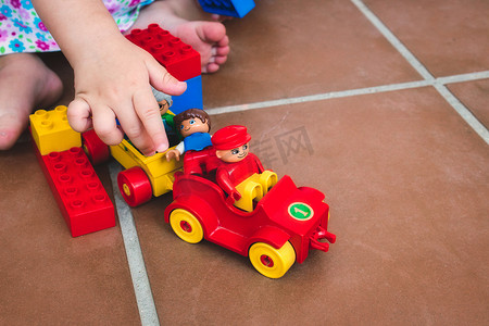 一个孩子在玩 Duplo 玩具、人物和车辆