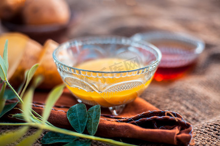 马铃薯汁的面膜或面膜在黄麻袋表面的玻璃碗中，由马铃薯汁和蜂蜜组成。与整个成分一起用于皮肤美白目的。水平低角度。