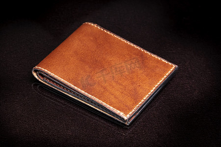 深色背景上的棕色皮革钱包。