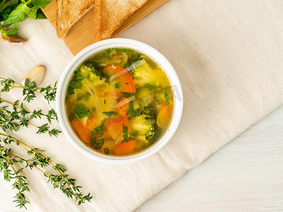膳食搭配摄影照片_美味的浓汤搭配混合蔬菜 - 花椰菜、西兰花、胡萝卜、土豆、大蒜、西红柿。