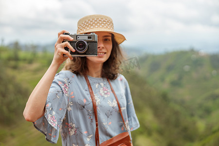 微笑的女性旅行者使用相机拍摄照片