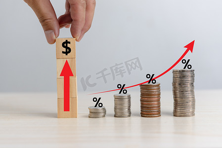 红色金融投资摄影照片_商业金融投资经济堆叠硬币通货膨胀和箭头红色与木立方体百分比在桌子上。